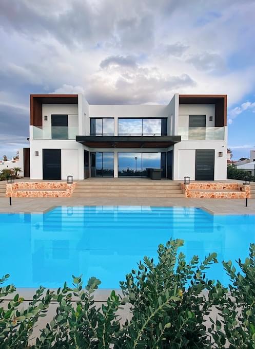 Two-floor villa with a swimming pool in front of it